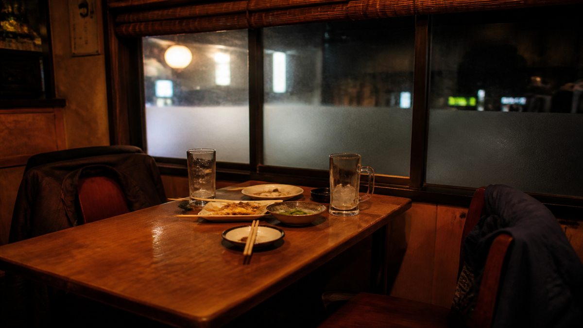 久しぶりの再会を思わせる二人分の飲み物がある居酒屋の席